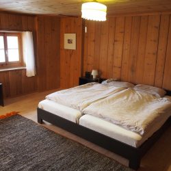 Erstes Schlafzimmer des Ferienhauses mit Wänden, Decke und Boden aus Holz