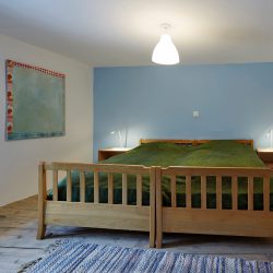 Zweites Schlafzimmer der Chasa Bügl Suot mit weiss-blau gestrichenen Wänden